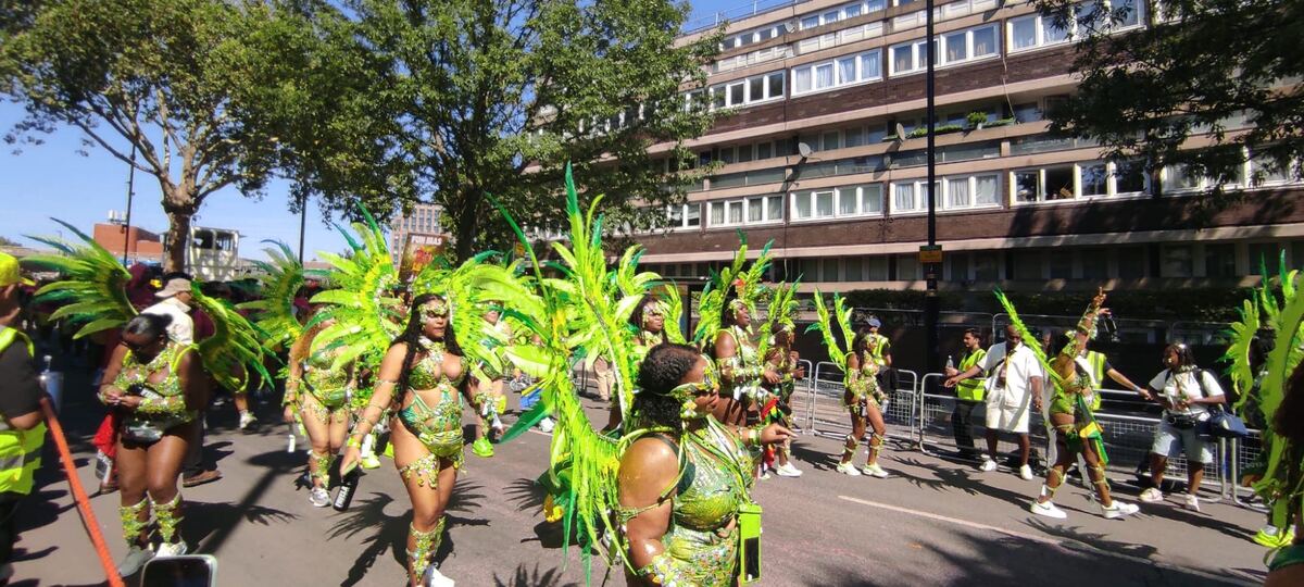 Carnival parade in green feathered costumes